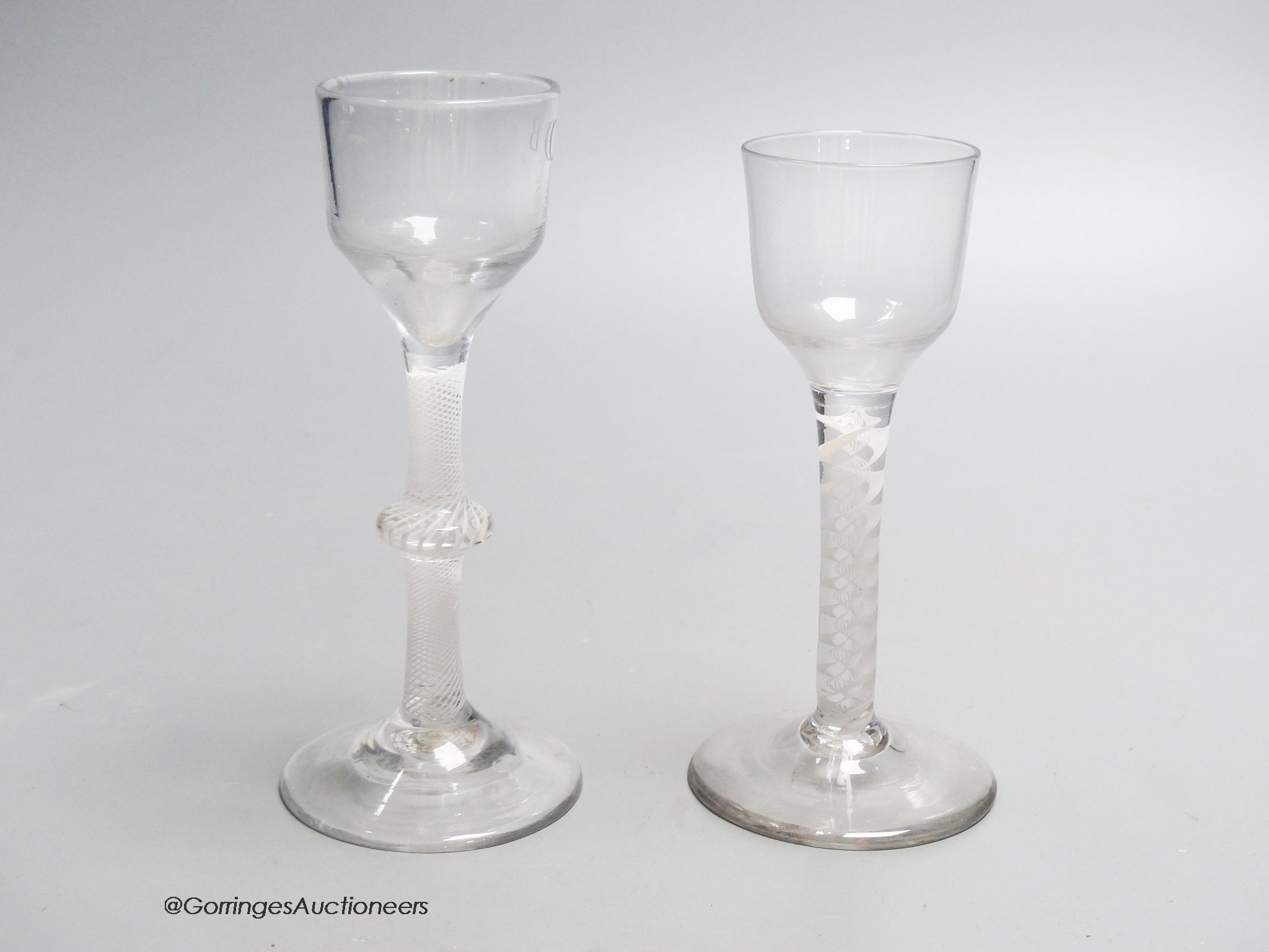 Two Georgian opaque twist stem cordial glasses, each with a funnel bowl, one engraved C B with dove and olive branch, tallest 15cm